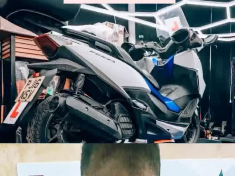 A Honda Forza scooter up on the workbench being worked on at 63 Motors