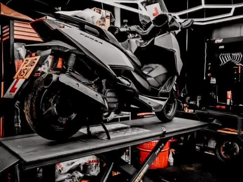 A scooter raised on the lift inside the 63 Motors workshop